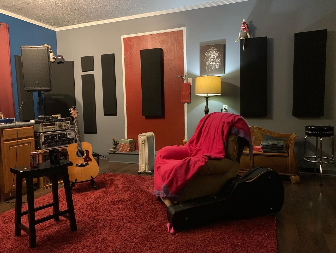 Studio corner with acoustic panels, a guitar and a cozy chair